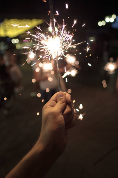 istock Hand with Sparkler. blurry sparks and background 1177234604