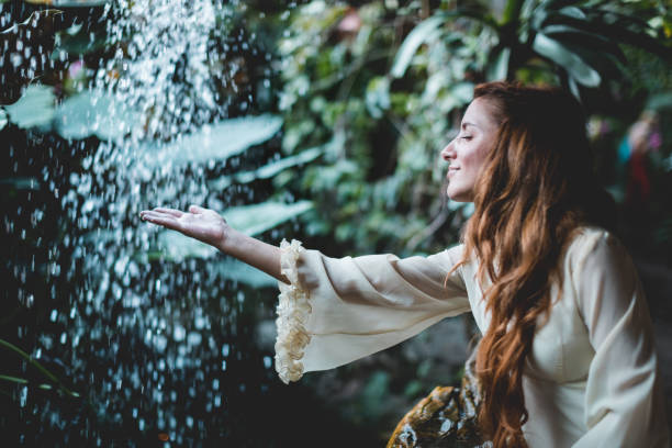 frau im weißen kleid steht gegen wasserfall - waterfall water nature zen like stock-fotos und bilder