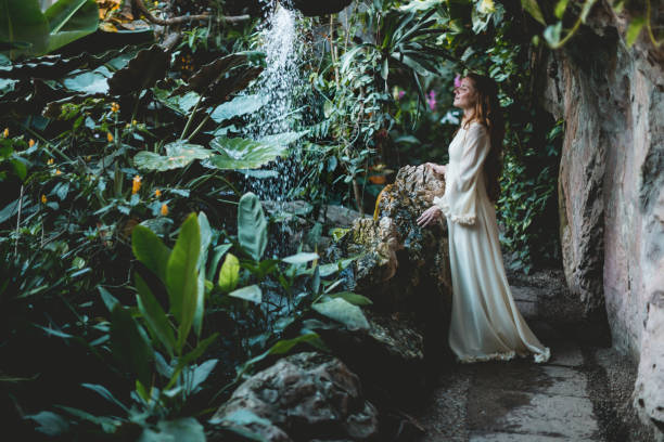 frau im weißen kleid steht gegen wasserfall - waterfall water nature zen like stock-fotos und bilder