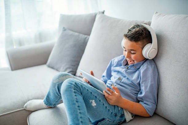 concentrated kid playing with digital tablet - filipino ethnicity audio imagens e fotografias de stock