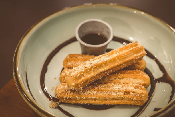 istock Churros Fried Spanish donuts (x4) stacked and served with chocolate dip in a bowl 1177236249