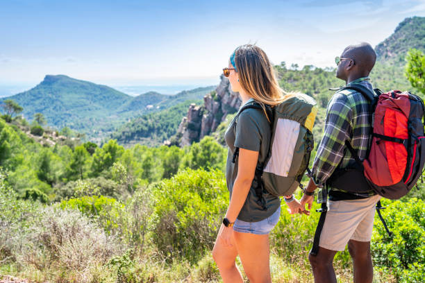 istock Couple ethnic trekking looking at mountain peak 1177237191