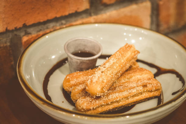 istock Churros Fried Spanish donuts (x4) stacked and served with chocolate dip in a bowl 1177237271