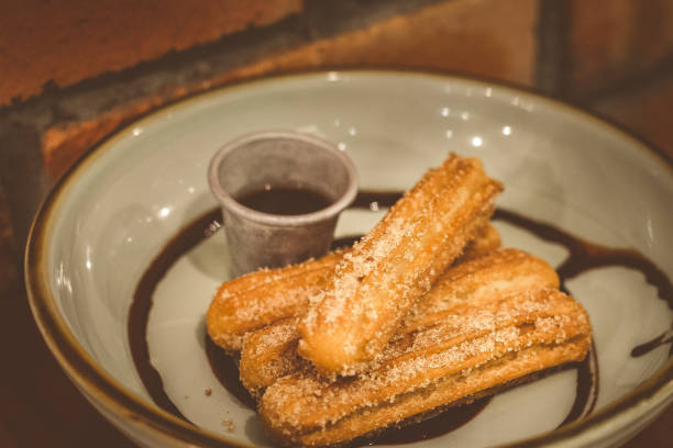 istock Churros Fried Spanish donuts (x4) stacked and served with chocolate dip in a bowl 1177237384