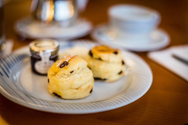 istock three raisin scones on a white china plate with fruit jam on the side 1177240680