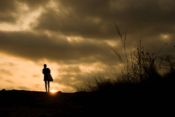 istock silhouette of lonely person walking with sunset 1177242018