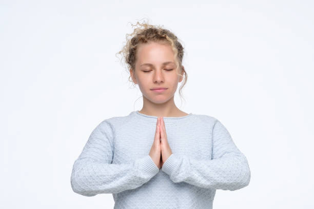 istock Woman holding hands in namaste or prayer, keeping eyes closed while meditating 1177243739