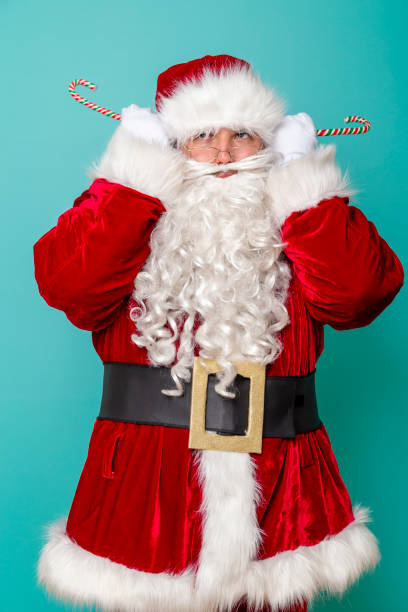 istock Santa Claus holding candy cane ears 1177244513
