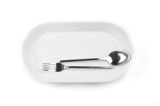 The isolate white kitchen set of plate, spoon, and folk for meal at home and restaurant