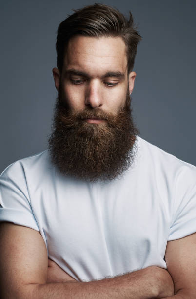 istock Bearded young man standing thoughtfully with his arms crossed 1177246164
