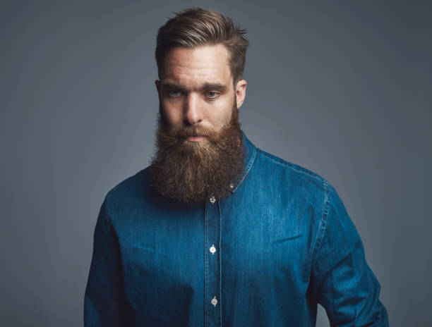 istock Bearded young man praying against a gray background 1177246192