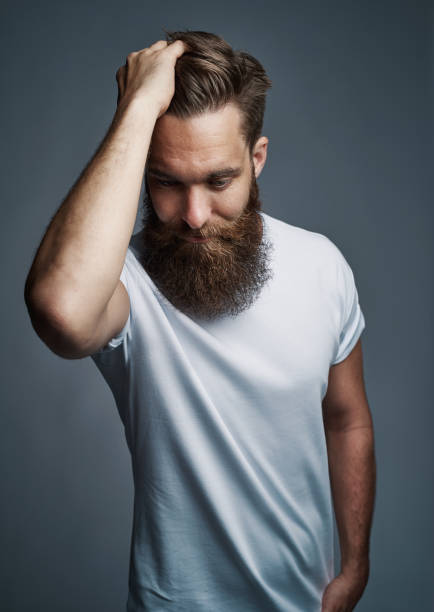 istock Cool young hipster standing with a hand in his hair 1177246222