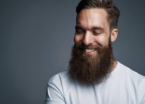 istock Smiling bearded hipster standing against a gray background 1177246578