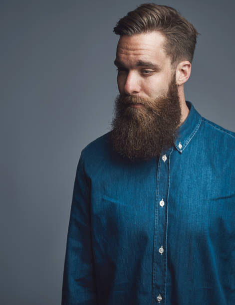 istock Bearded young man standing pensively against a gray background 1177246634