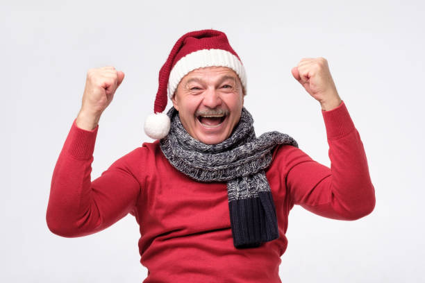 joyeux homme hispanique mûr dans le chapeau de noel est heureux avec des cadeaux et criant wow - men sweater excitement satisfaction photos et images de collection