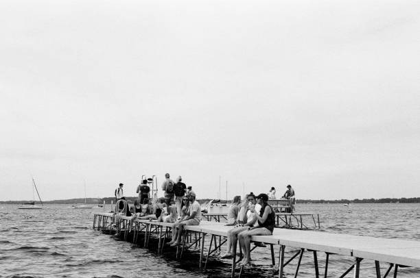 Madison, WI - July 4, 2019. Views of Lake Mendota with the general public enjoying the summer holiday at the University of Wisconsin-Madison Student Union on US Independence Day 2019. The UW-Madison student union is a popular gathering and recreation place for families, college students, and the general public of Madison, WI. Shot on black and white film for vintage look