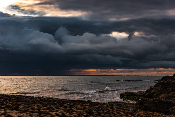 nuages nuageux foncés épais au-dessus de la mer - turbulence photos et images de collection