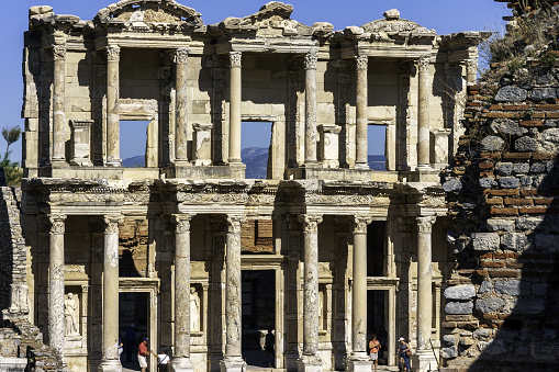 Marble Columns and statues, a clear blue sky, and fine stone carving highlight one of the most beautiful structures in all of Ephesus, the historic Library at Ephesus in Turkey.
