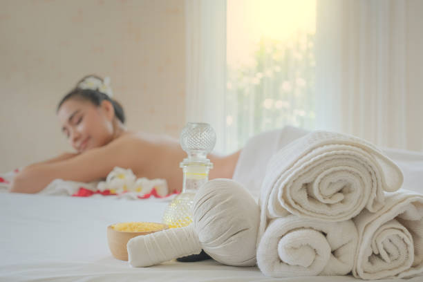 Spa treatment set and aromatic massage oil on bed massage. Thai setting for aroma therapy and massage with flower on the bed, relax and healthy care.