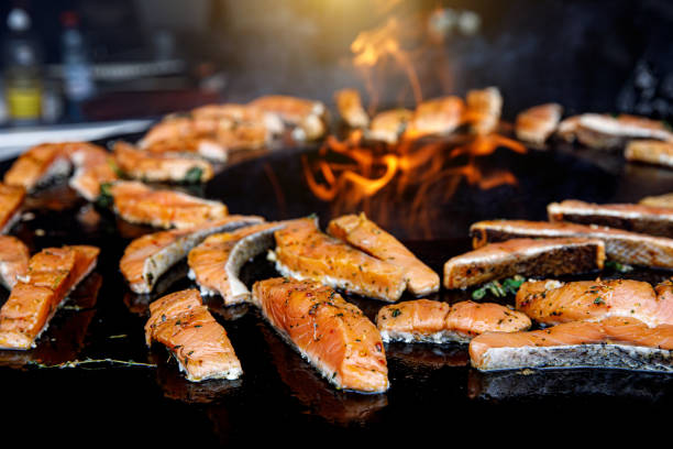 istock Grilled salmon fish with various vegetables on pan near the fire. 1177261596