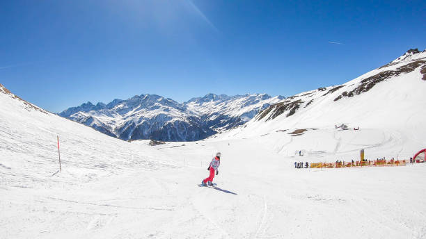 istock Heiligenblut - A snowboarder going down the slope 1177262314