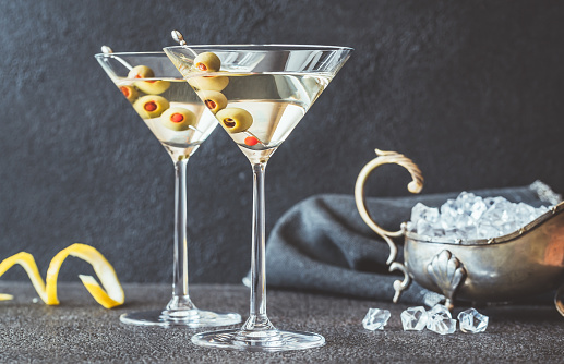 Two glasses of martini cocktail garnished with green olives