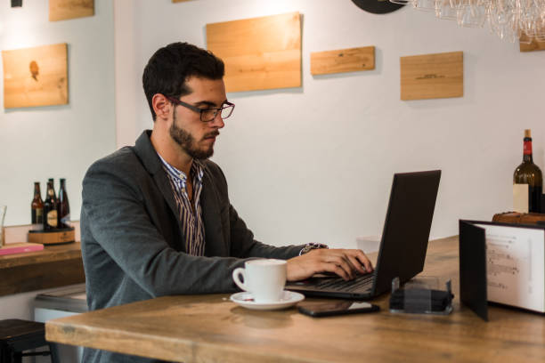 istock Young businessman in a pub working with his laptop 1177268931