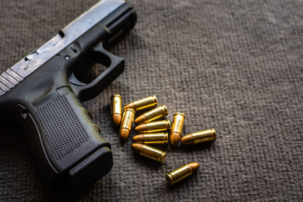 istock bullets and gun on black velvet desk 1177268976