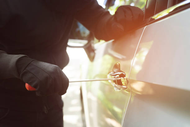 istock Close up hand pulling the handle of a car thief wearing black clothes and glove stealing automobile trying door handle to see if vehicle is unlocked trying to break into. car theft concept. 1177268977