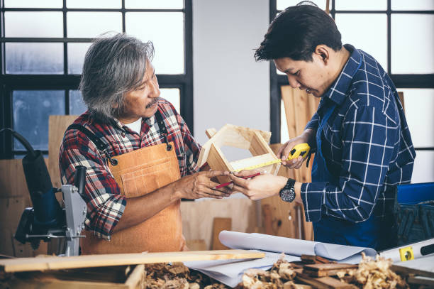 istock Two carpenters working in shop  wood craftsman 1177271131