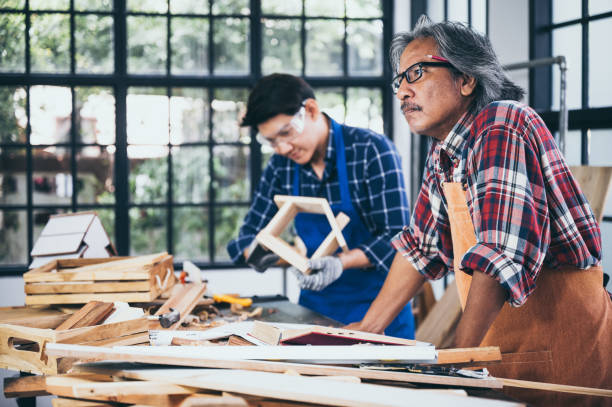istock Two carpenters working in shop  wood craftsman 1177271132