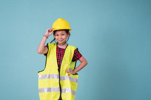 Image of Asian Little Cute Construction Worker with green color background.