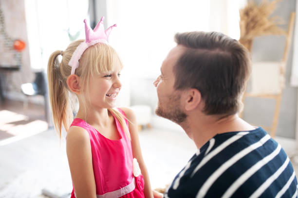 istock Daughter wearing dress and crown talking to daddy 1177274353