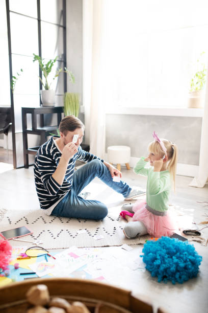 istock Daddy and girl sitting on the floor and studying letters 1177274404