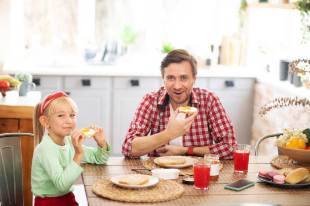 istock Father and daughter enjoying weekend breakfast at home 1177275397