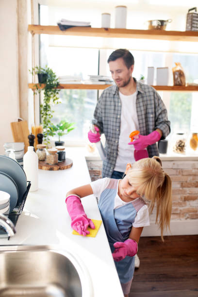 istock Daughter wearing gloves helping daddy to clean kitchen 1177275592