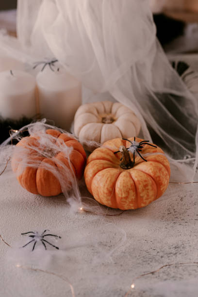 istock Spooky Halloween decoration with different pumpkins, light, spiders. Halloween table decoration. 1177277620