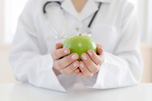 istock Female doctor holds green apple 1177277818