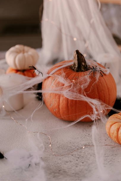 istock Spooky Halloween decoration with different pumpkins, light, spiders. Halloween table decoration. 1177279714