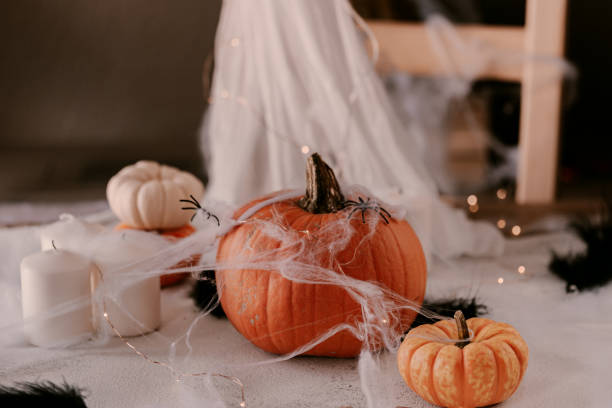 istock Spooky Halloween decoration with different pumpkins, light, spiders. Halloween table decoration. 1177279836