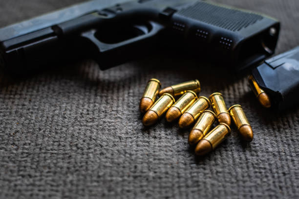 istock bullets and gun on black velvet desk 1177282492