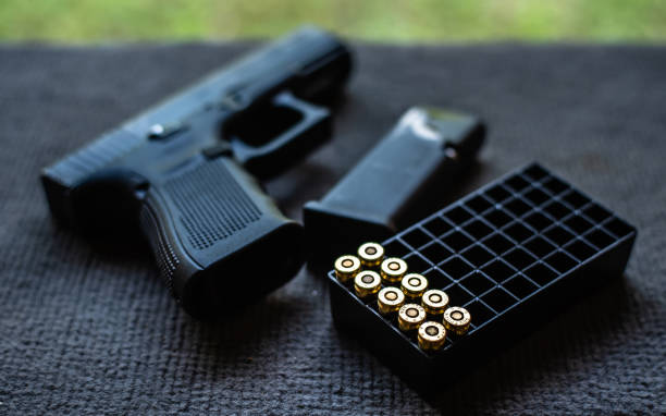 balas y pistola en el escritorio de terciopelo negro - nobody handgun gun part of fotografías e imágenes de stock