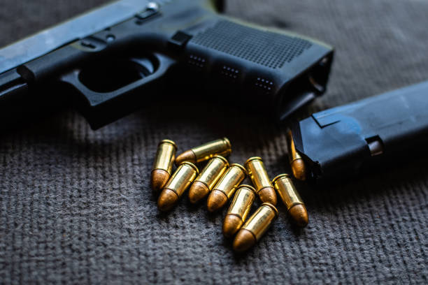 istock bullets and gun on black velvet desk 1177282595