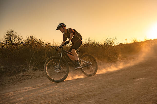 istock Mountian Biker Riding Through The Dust Into The Sunset 1177283427