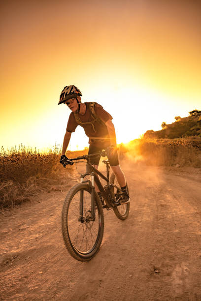 istock Mountian Biker Riding Through The Dust Into The Sunset 1177283464