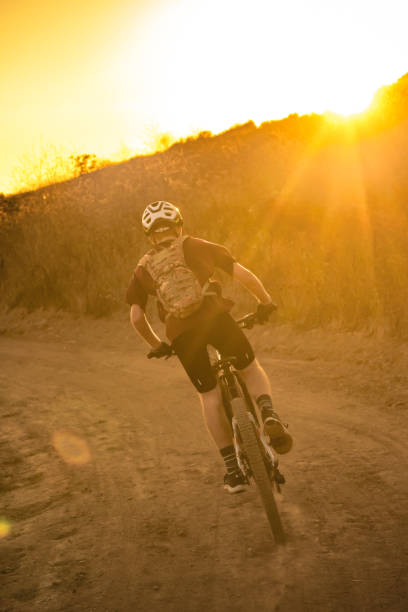 istock Mountian Biker Riding Through The Dust Into The Sunset 1177283531