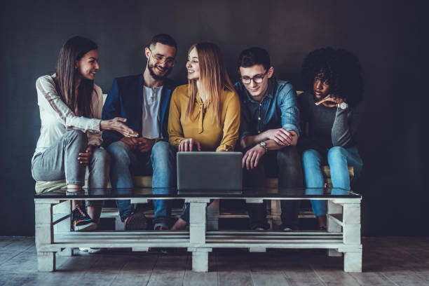 istock Group of business people sitting together on the couch and discussing something while looking at the laptop 1177284001