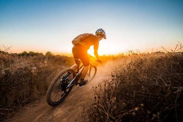 Mountian Biker Riding Into The Sunset A young Mountain Biker Riding Into The Sunset at La Costa Preserve, Carlsbad California mountain biking stock pictures, royalty-free photos & images