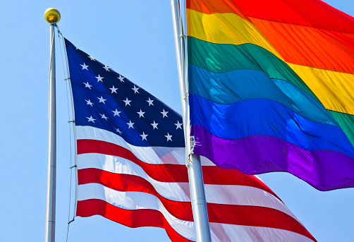 RAINBOW FLAG IN FRONT OF USA FLAG