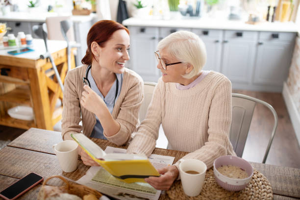 istock Woman and caregiver drinking tea and reading 1177288083